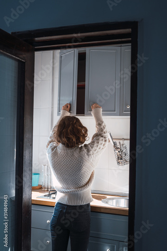 Young woman preparing breakfast in the kitchen on a sunny morning