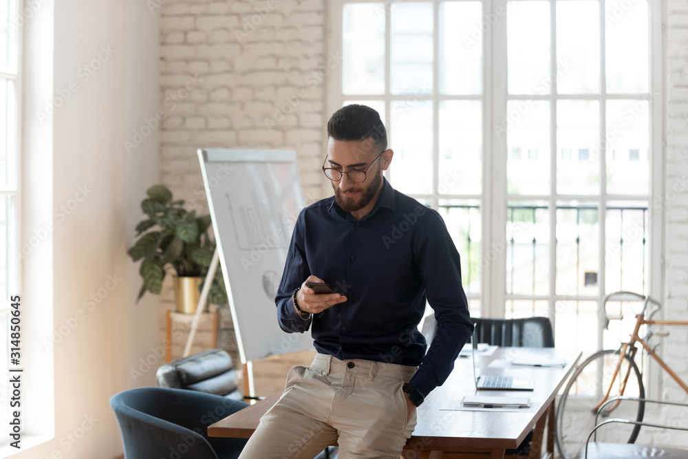 Arabian businessman busy using modern smartphone in office Arabian businessman busy using modern smartphone in office