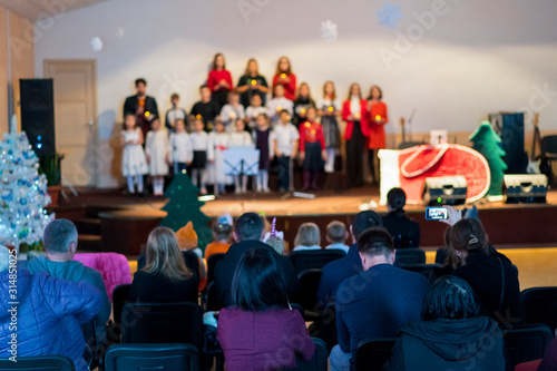 Wallpaper Mural Many parents are watching the kids performance in the hall. Children on stage perform in front of parents. Young talents on stage. Blurry Torontodigital.ca