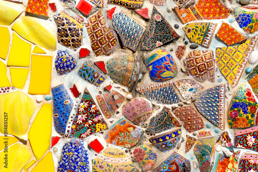 Fototapeta premium Abstract wall background decorated from colorful tile scrap and pottery.