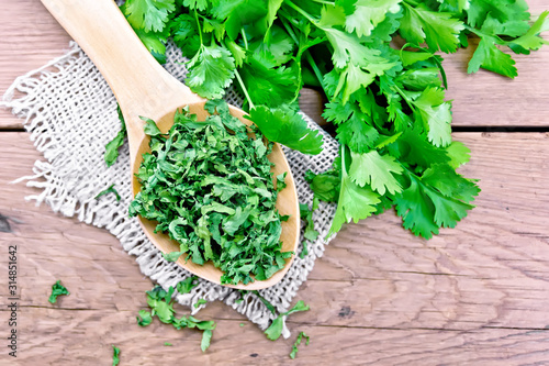 Cilantro dried in spoon on old board top photo