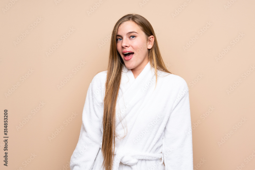 Obraz premium Teenager girl in a bathrobe over isolated background with surprise facial expression