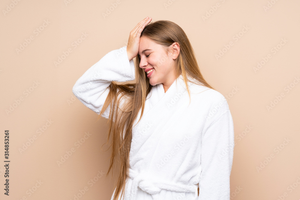 Teenager girl in a bathrobe over isolated background having doubts with confuse face expression Teenager girl in a bathrobe over isolated background having doubts with confuse face expression
