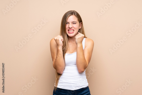 Teenager blonde girl over isolated background frustrated by a bad situation