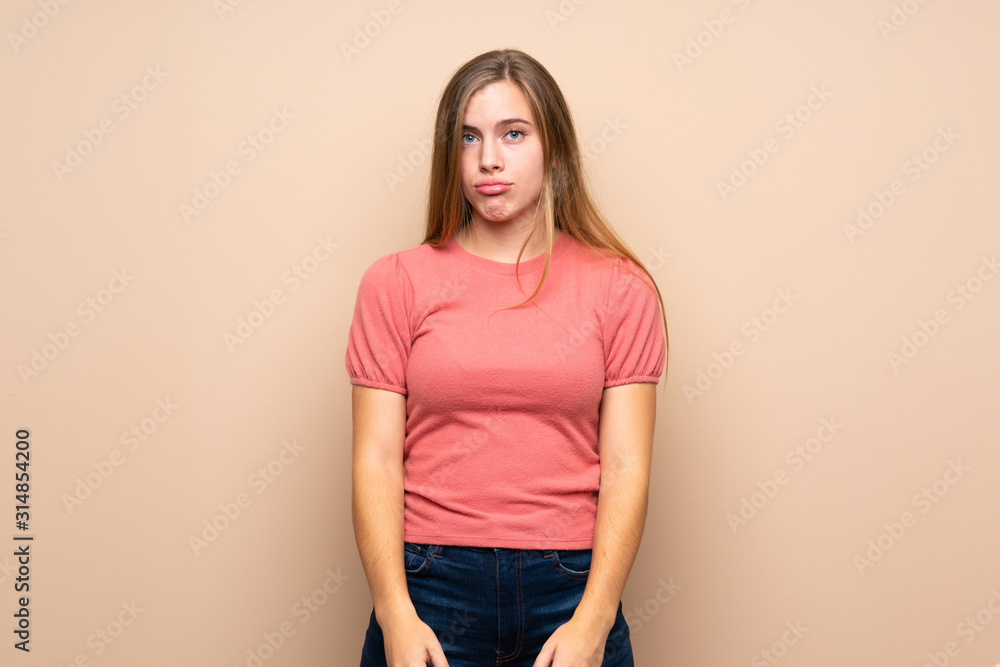 Teenager blonde girl over isolated background sad Teenager blonde girl over isolated background sad