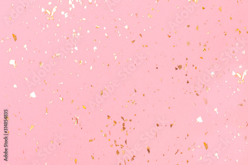 Golden sparkles on pink pastel trendy background. Festive backdrop for your projects.