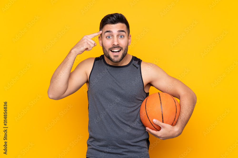 Handsome young basketball player man over isolated white wall intending to realizes the solution