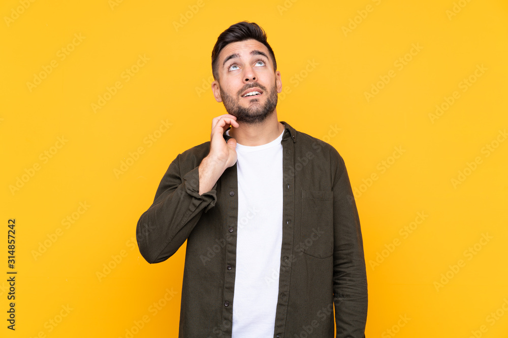 Man over isolated yellow background thinking an idea
