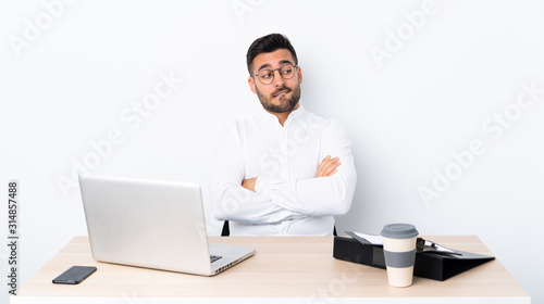 Young businessman in a workplace with confuse face expression