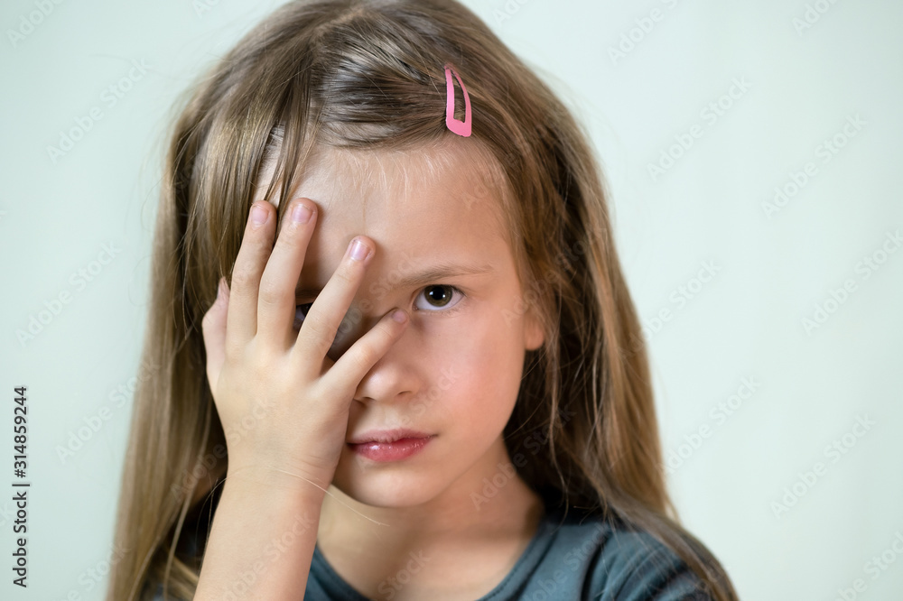 Close-up portrait of little child girl with long hair covering her mouth with hands. Close-up portrait of little child girl with long hair covering her mouth with hands.