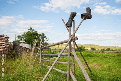 Wooden fence in the village, drying boots