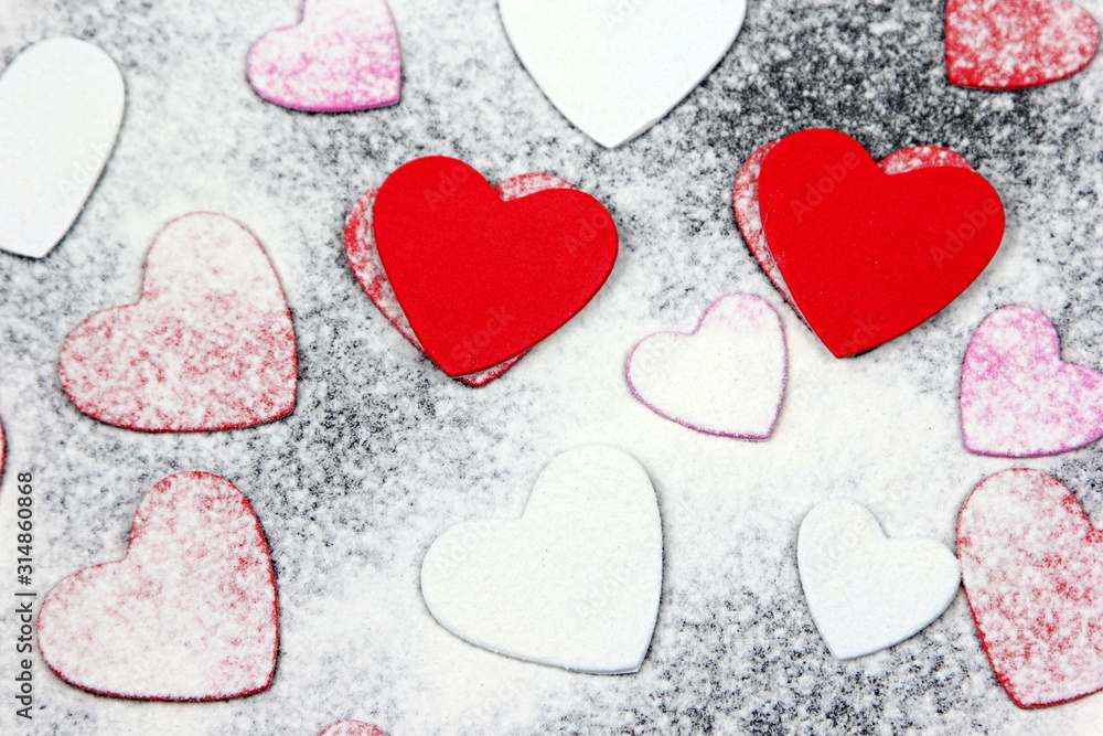 Red hearts on a black background with white powder. Valentines day concept.