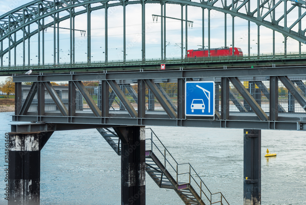 Φωτογραφία Hinweisschild für die Autoverladung auf ein Schiff mit einer Eisenbahnbrücke im