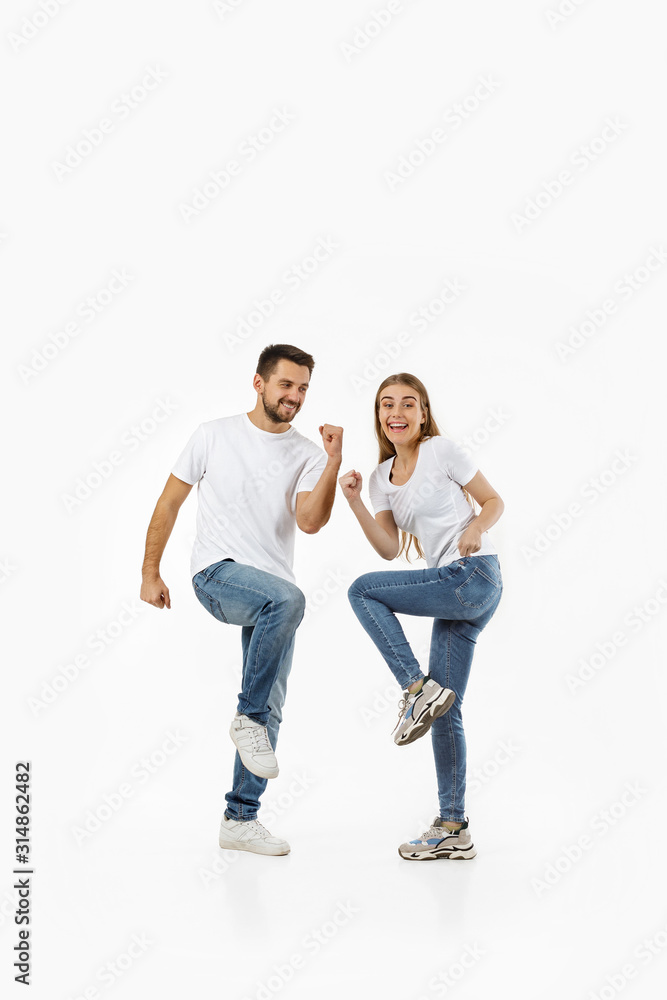 full length portrait of happy couple in casual outfit dancing on white background