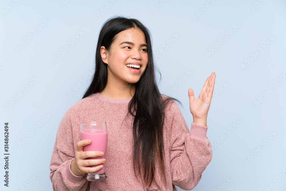Young teenager Asian girl with strawberry milkshake with surprise facial expression Young teenager Asian girl with strawberry milkshake with surprise facial expression