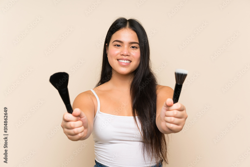 Young teenager Asian girl holding makeup brush Young teenager Asian girl holding makeup brush