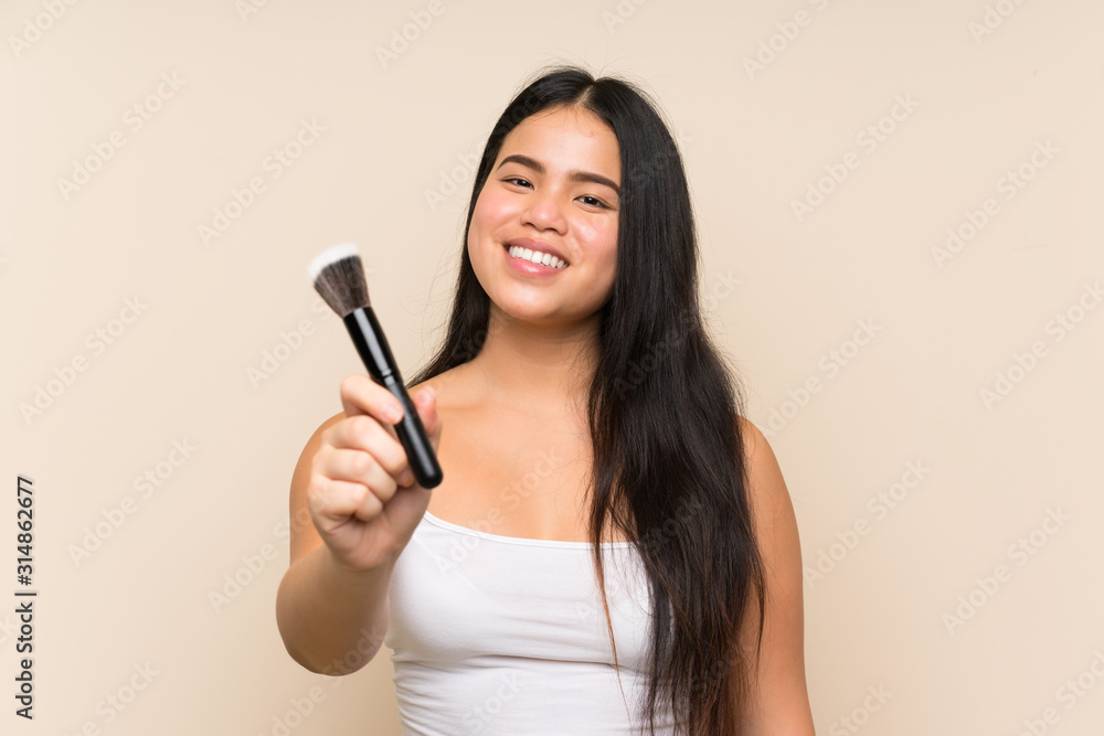 Young teenager Asian girl holding makeup brush
