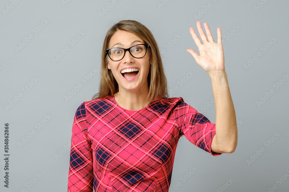 Young cheerful beautiful woman waiving saying hello Young cheerful beautiful woman waiving saying hello