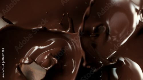 Super Slow Motion Shot of Raw Chocolate Chunks Falling into Melted Chocolate at 1000fps.