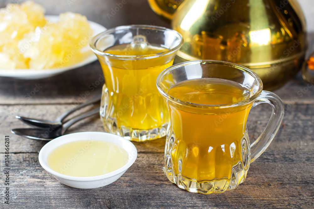 Oriental tea with honey and oriental sweets navat on wooden table background. Ramadan drink Oriental tea with honey and oriental sweets navat on wooden table background. Ramadan drink