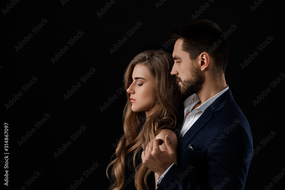 elegant couple on black background. man embracing beautiful woman in black dress. copy space elegant couple on black background. man embracing beautiful woman in black dress. copy space