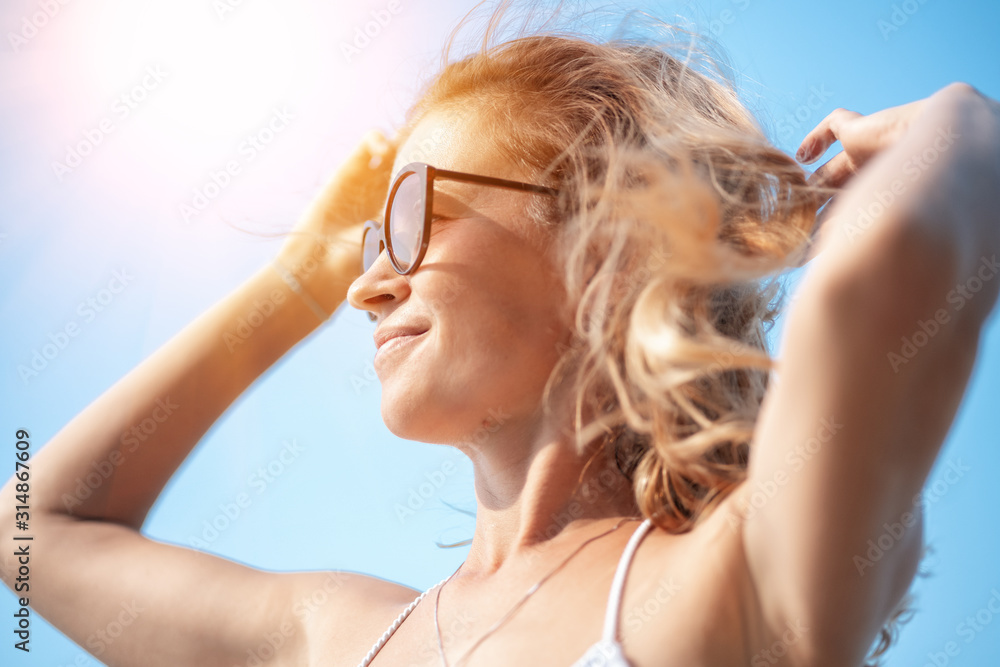 Fashion photo of beautiful tanned woman with blond hair in elegant white bikini and sunglasses relaxing on tropical island with perfect beach. Fashion photo of beautiful tanned woman with blond hair in elegant white bikini and sunglasses relaxing on tropical island with perfect beach.