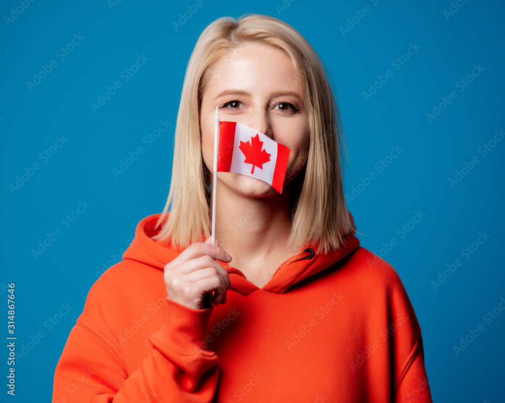 girl holds flag of Canada on gray background girl holds flag of Canada on gray background