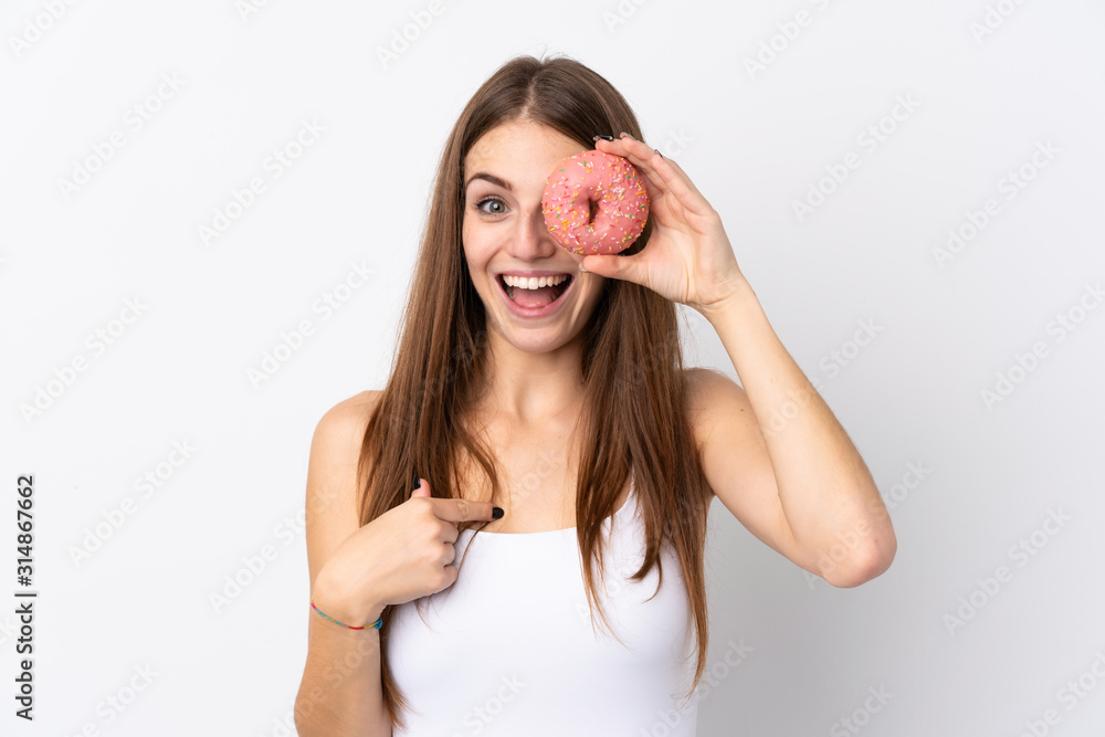 Young woman over isolated white background holding a donut and happy