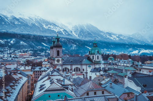 Aerial church view in Innsbruck with snow covered mountains on the background