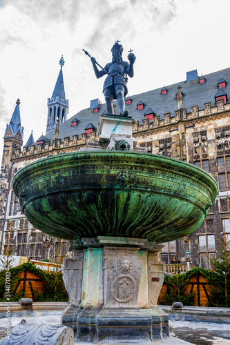 The old Karlsbrunnen or Charlemagne Fountain in front of the Aachen Town Hall in Germany, low-angle view