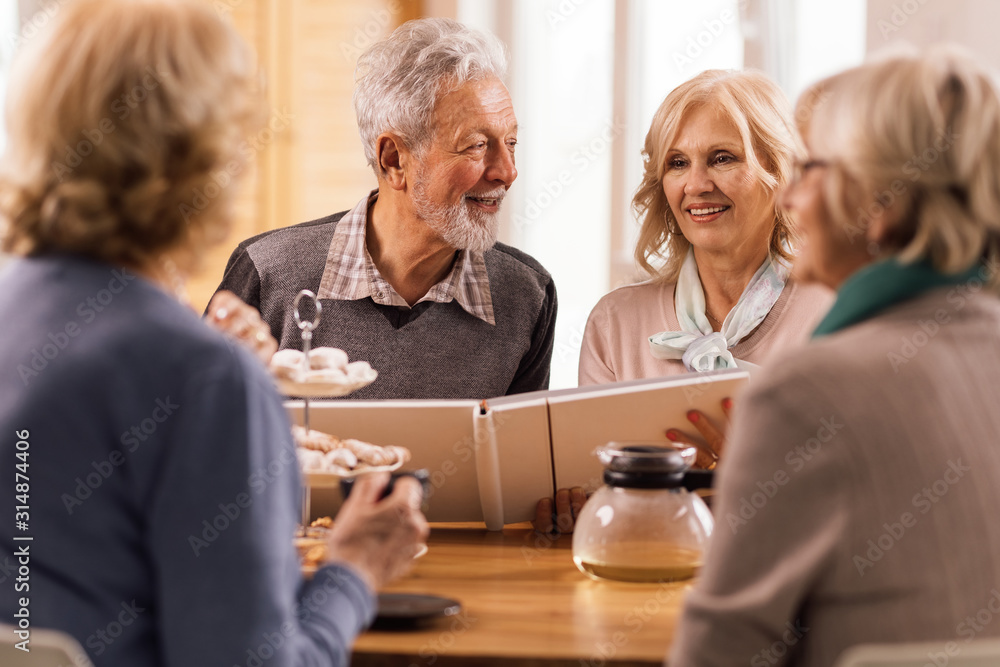 Happy senior couple looking at photo album at home. Happy senior couple looking at photo album at home.