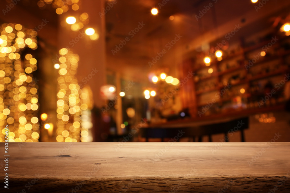 background Image of wooden table in front of abstract blurred restaurant lights