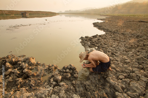Canvas Print Man taking water from drying pond, river on summer metaphor water crisis and climate change impact