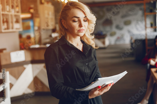 Pretty businesswoman working. Cute girl standing at the caffee. Woman use the notebook