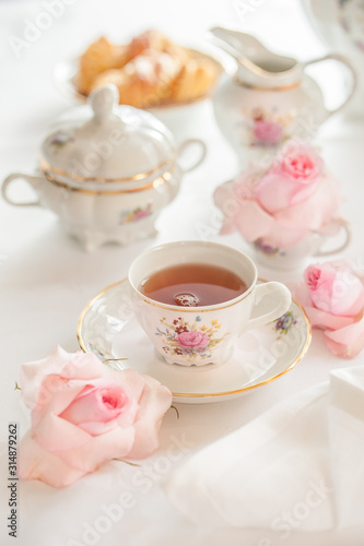 Tea time served with  fine china porcelain set with floral pattern. 