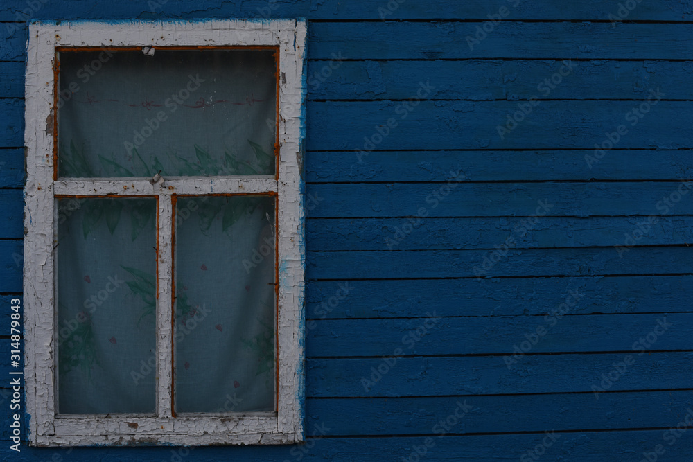 Old window in a wooden house. boards are painted blue Old window in a wooden house. boards are painted blue
