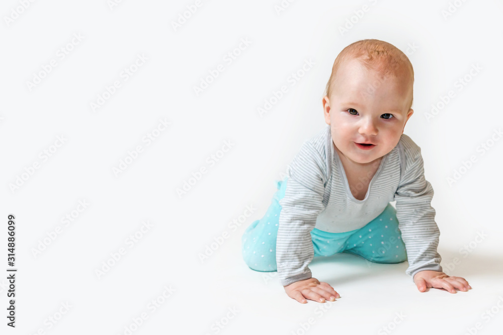 Cute little baby boy is kneeling smiling at the camera. All on the white background