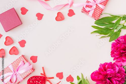 Flat lay valentines day frame with red peonies and gift box on a color background