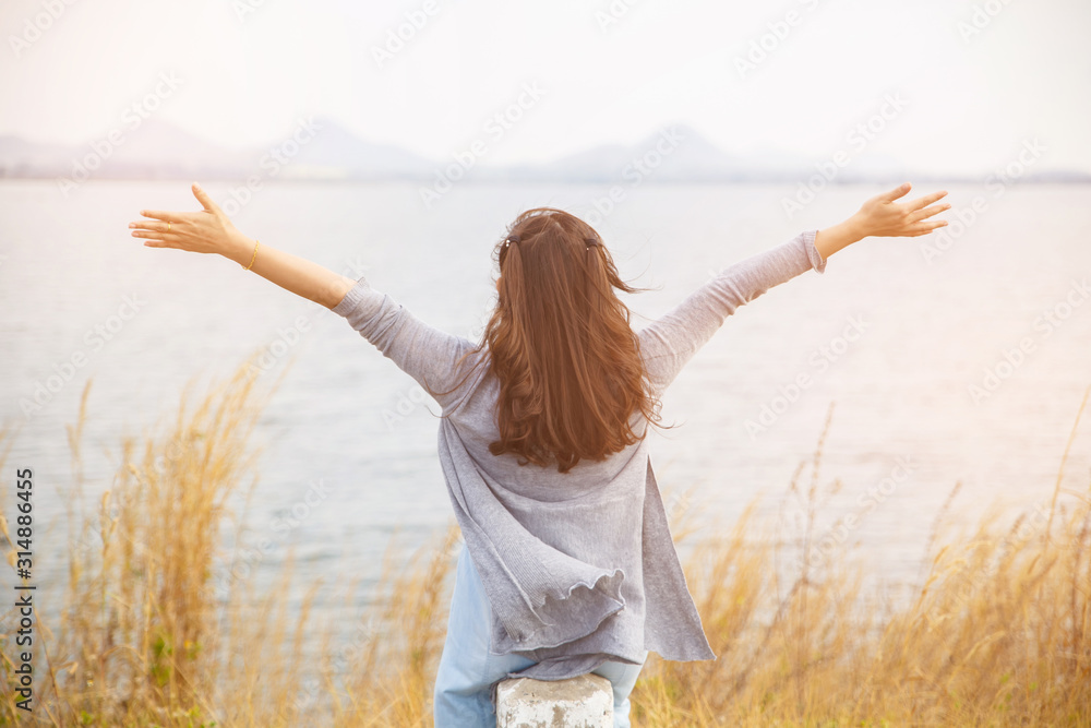 Back view of woman sit on the side of road with tree around, Asian traveler girl stand turn back and looking to far.