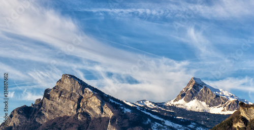 winter mountain landscape with rocky and jagged snowy peaks under blue sky photo