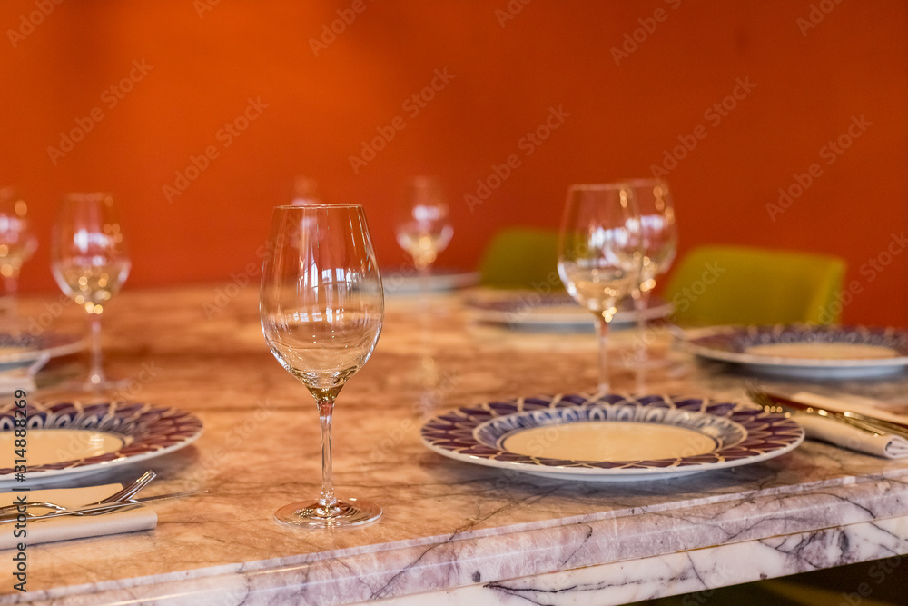 Empty glasses in restaurant. Wine glass,banquet ,dining table settings decoration serving with dishes, glass, napkins on wooden dining table interior contemporary concept.Part of interior Empty glasses in restaurant. Wine glass,banquet ,dining table settings decoration serving with dishes, glass, napkins on wooden dining table interior contemporary concept.Part of interior