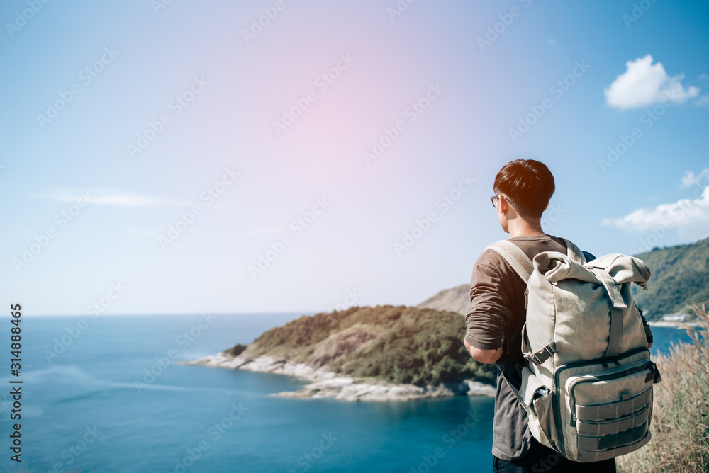 Fototapeta premium Man tourist with backpack on the mountain see the beautiful nature landscape of the sea
