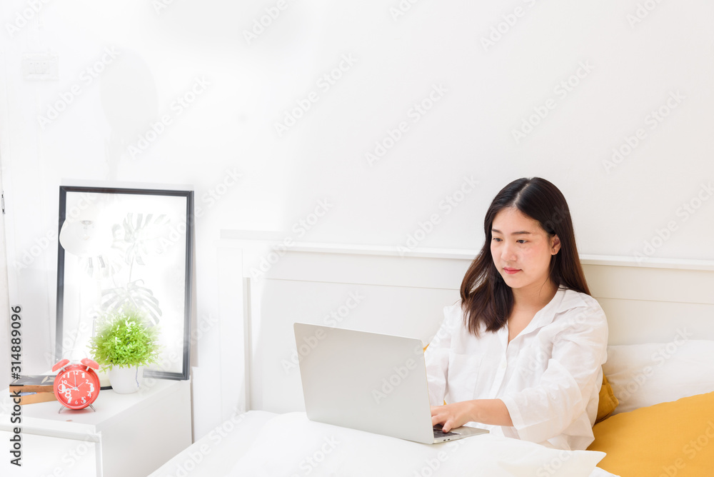 Young woman lying in bed, using laptop computer Searching more data/information on the internet online or Enjoy online shopping and social chat Young woman lying in bed, using laptop computer Searching more data/information on the internet online or Enjoy online shopping and social chat