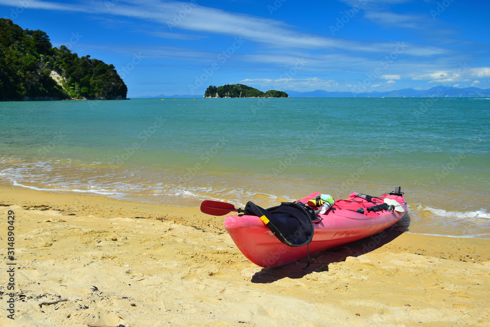 A red kayak on the beach of the Abel Tasman National Park. New Zealand, South Island.