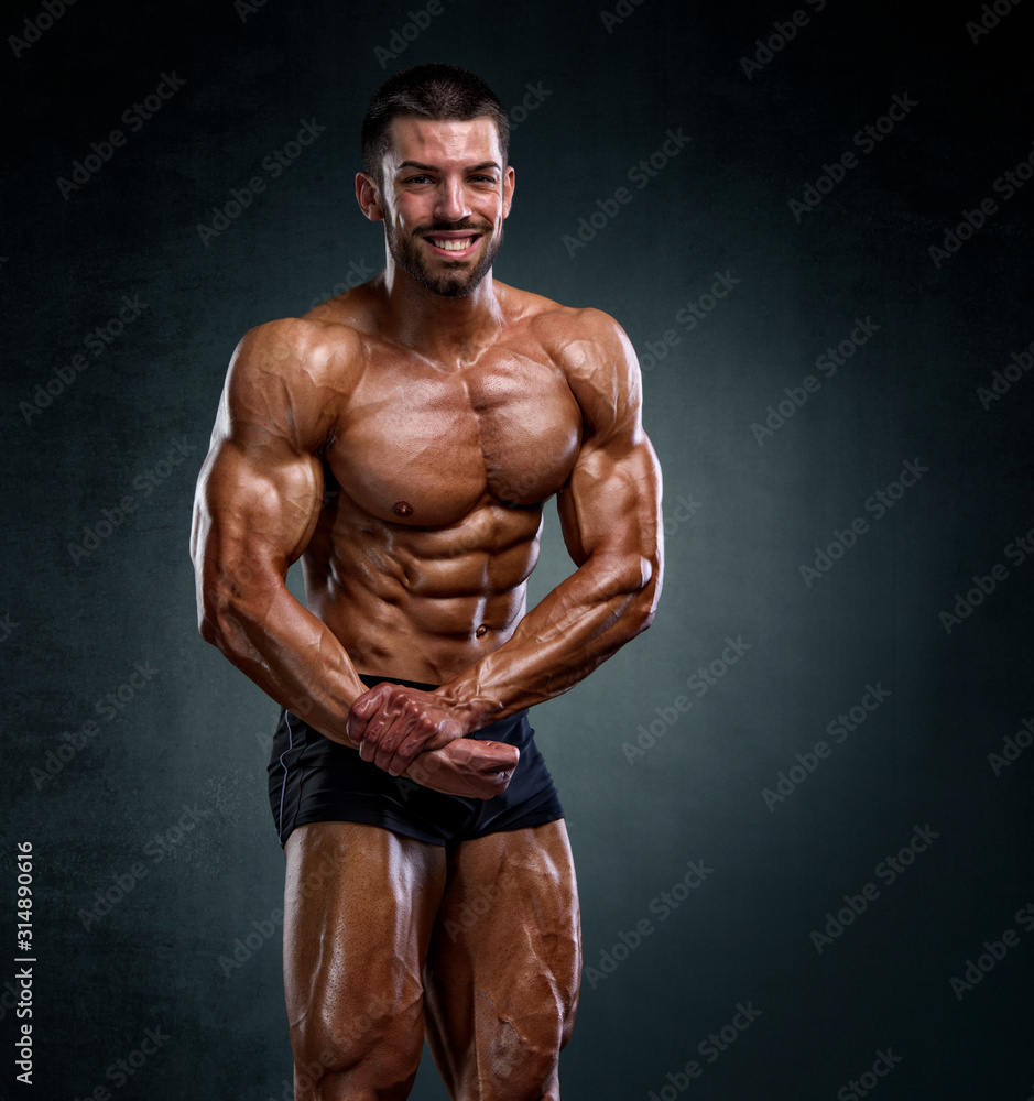 Fototapeta premium Bodybuilder Posing and Flexing Muscles. Studio Shot