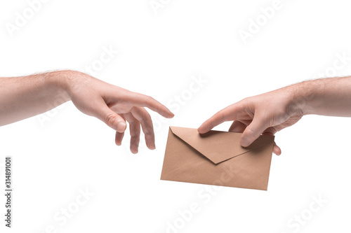 Two male hands passing one another a craft paper envelope on white background