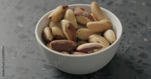 brazil nuts in white bowl on terrazzo countertop