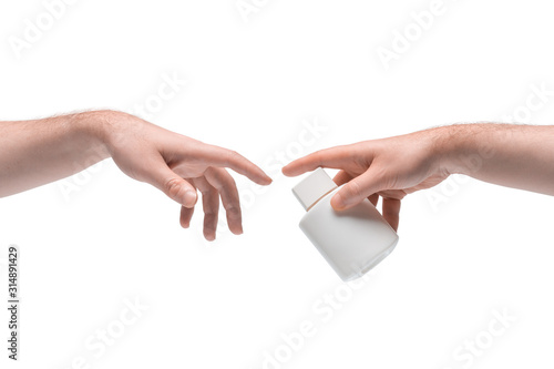 Two male hands passing one another small white bottle on white background (ID: 314891429)