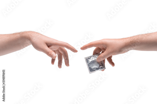 Two male hands passing one another a condom in package on white background