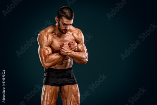 Bodybuilder Posing and Flexing Muscles. Studio Shot
